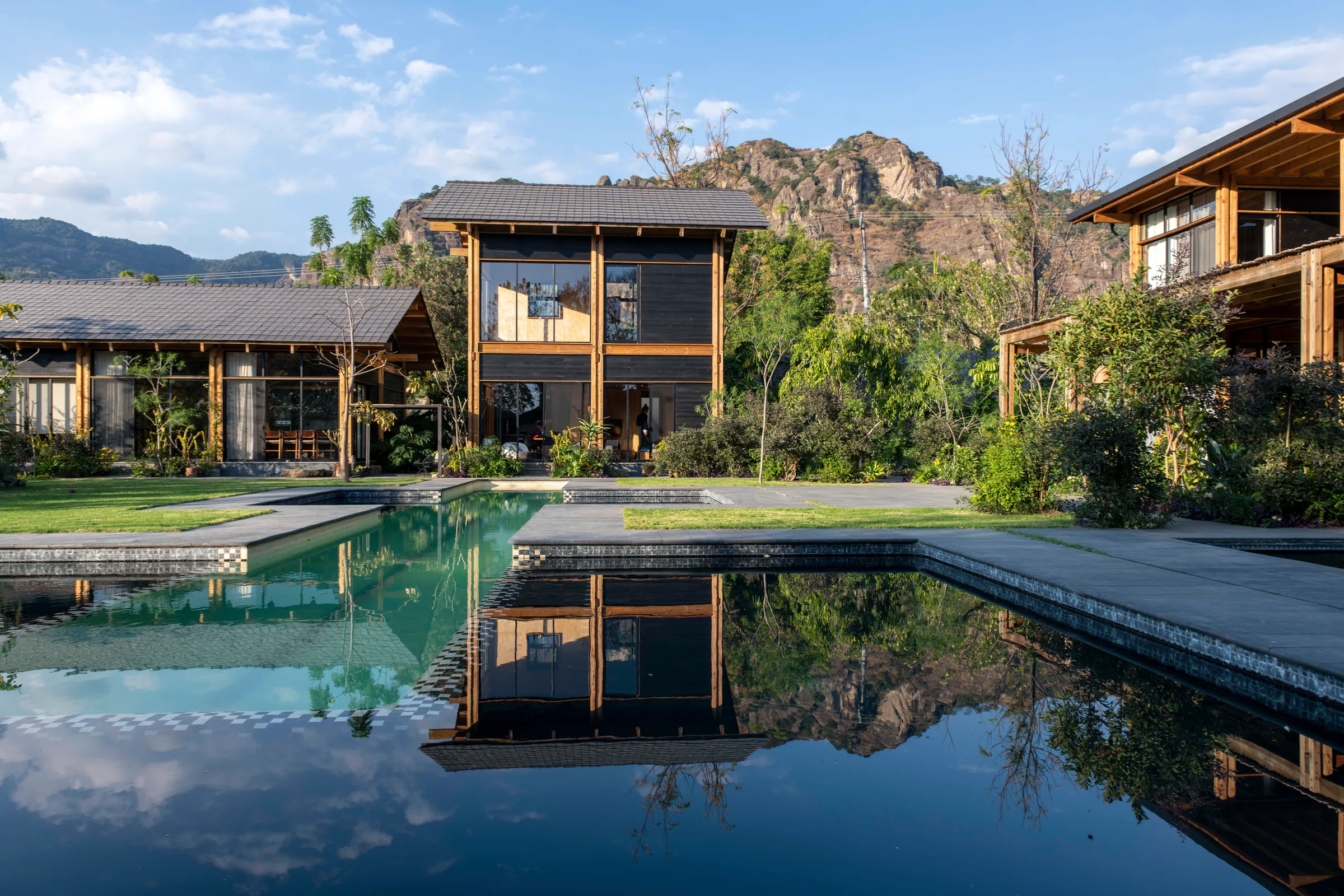 Espejo de agua reflejando la arquitectura Kineki en Tepoztlán, ante los acantilados del Tepozteco